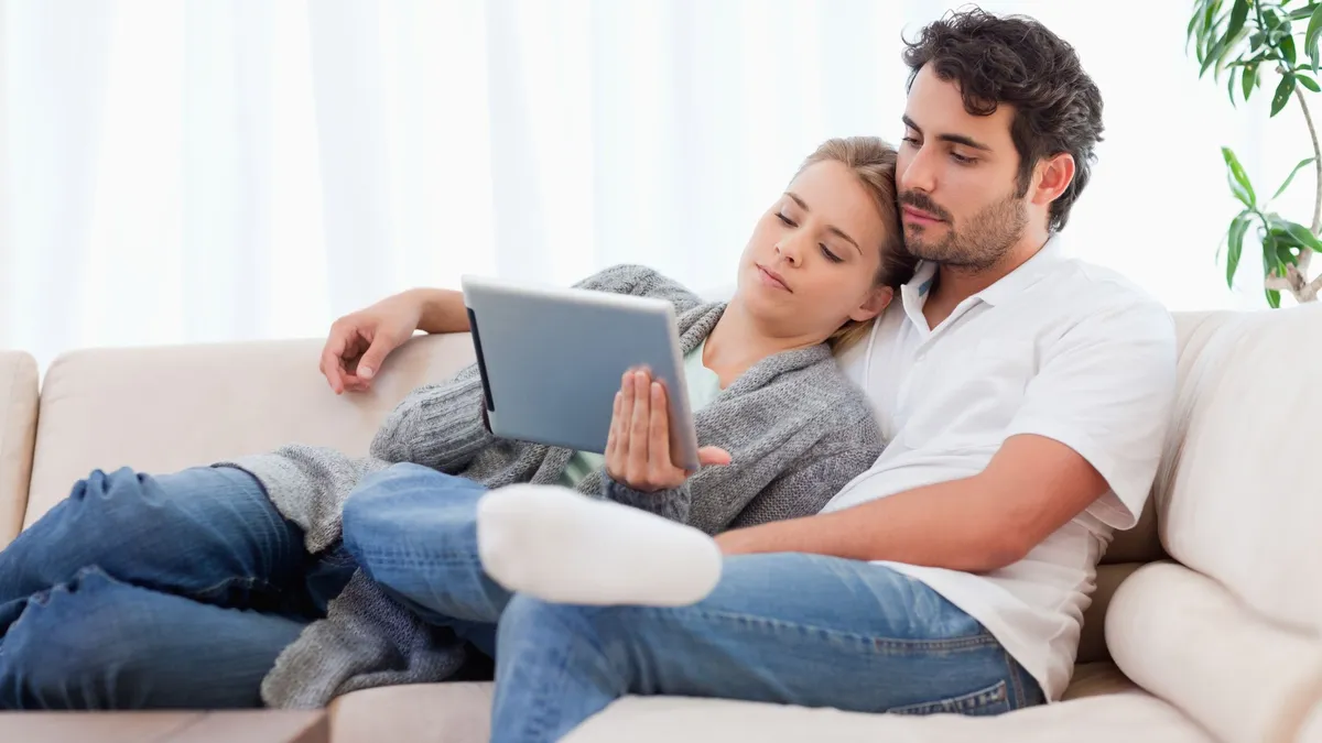 Sicherheit für die Familie. Entspannte Familie auf dem Sofa, geschützt durch klassische Versicherungen.