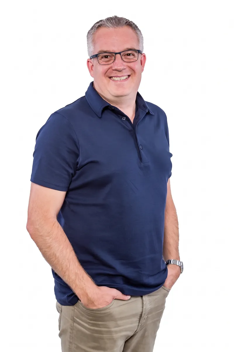 Ihr persönlicher Finanzberater Sascha Zilk, Experte für Finanzberatung in Regensburg, lächelt im blauen Poloshirt.